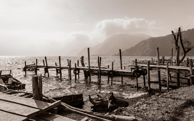 vieux-piliers-en-bois-délabrés-dans-le-lac-atitlan-au-guatemala-en-noir-et-blanc-97208020